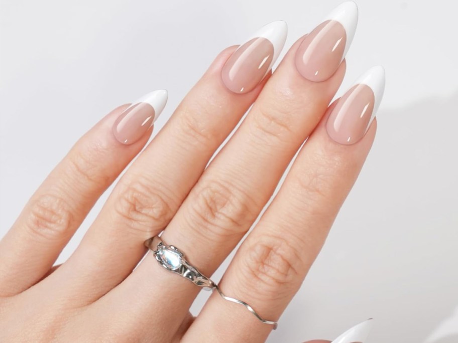 woman's hand with almond shaped french tip nails