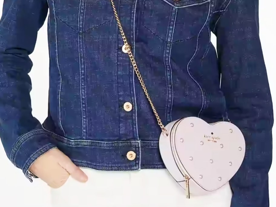 woman in jean jacket with purple heart crossbody bag