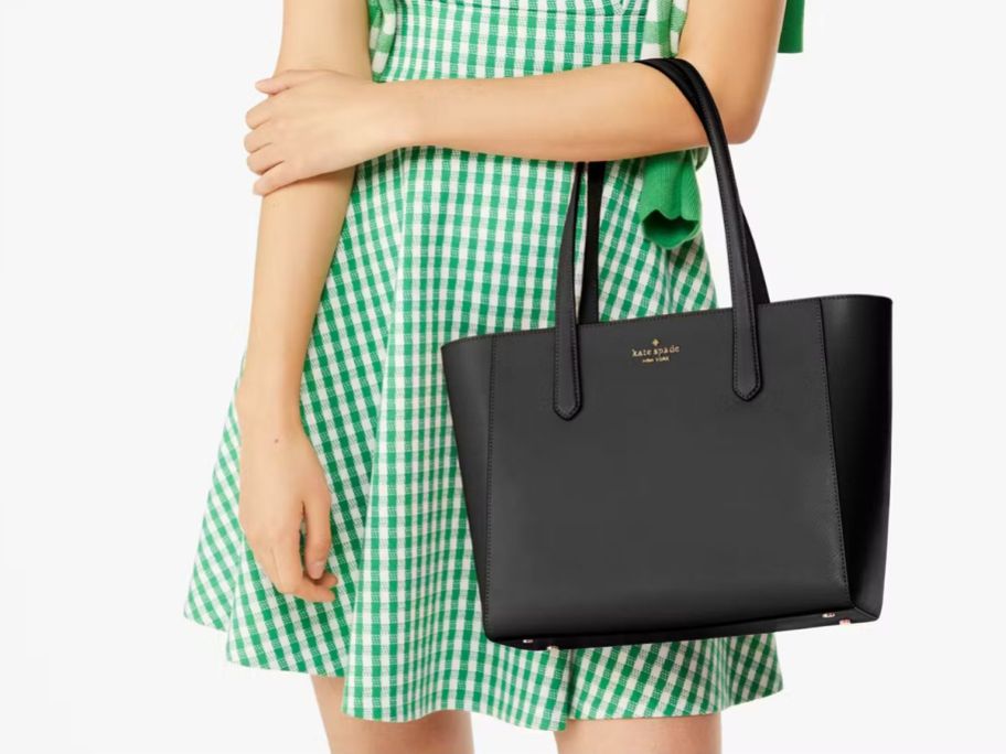 A woman with a black Kate Spade Staci Medium Tote 