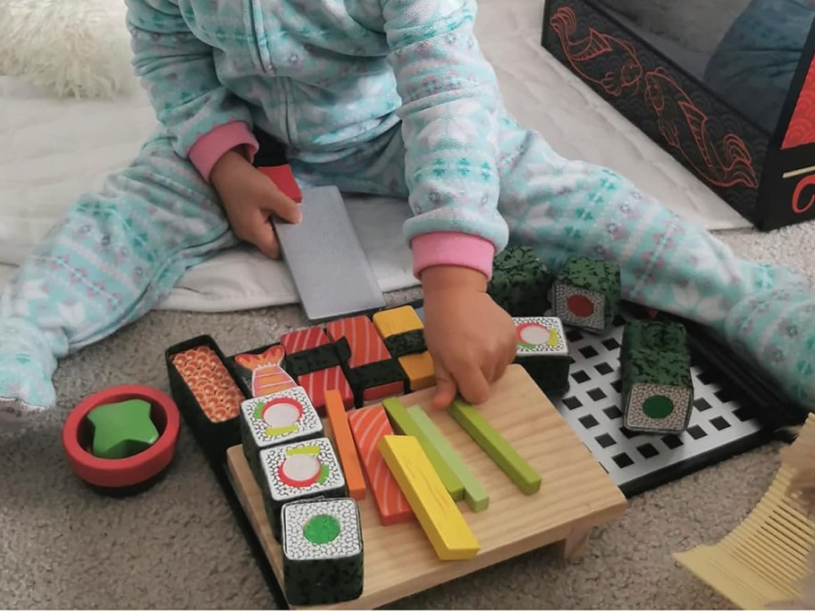 Kid playing with sushi playset on the floor