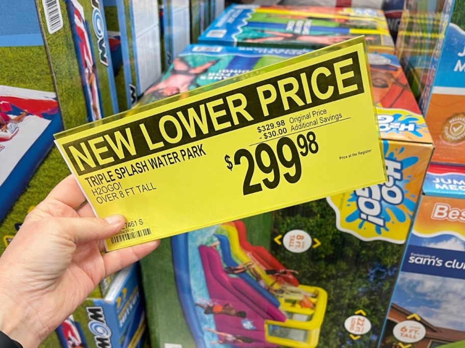 person holding price sign up in store in front of water slides