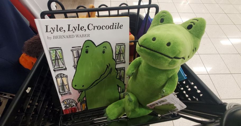 A Kohls Cares Plush Crocodile with book in a cart