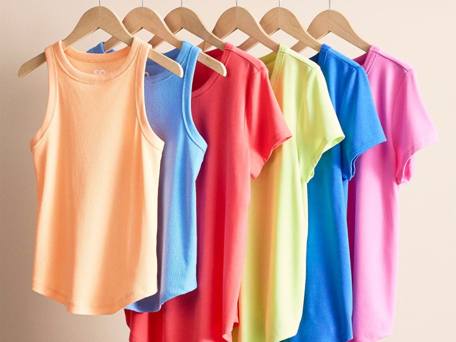 colorful tops and tanks on wood hangers