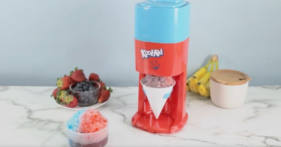 A kool-aid electric ice shaver next to a cup of 