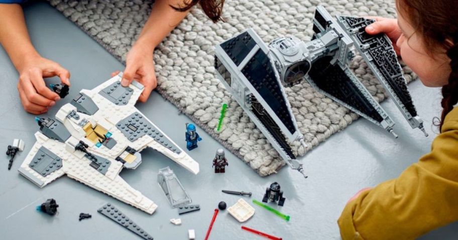 2 kids playing with LEGO Star Wars ships