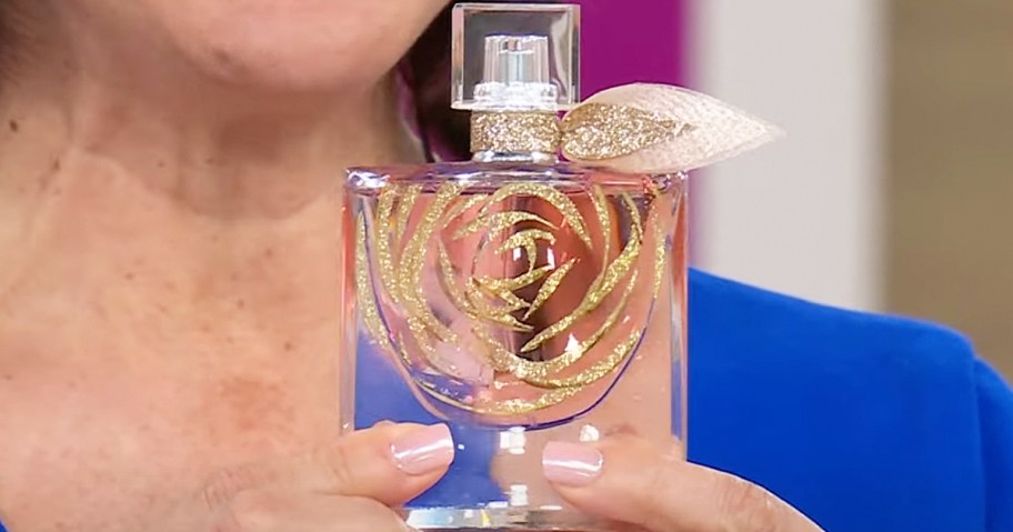 woman holding up a bottle of Lancome La Vie Est Belle perfume