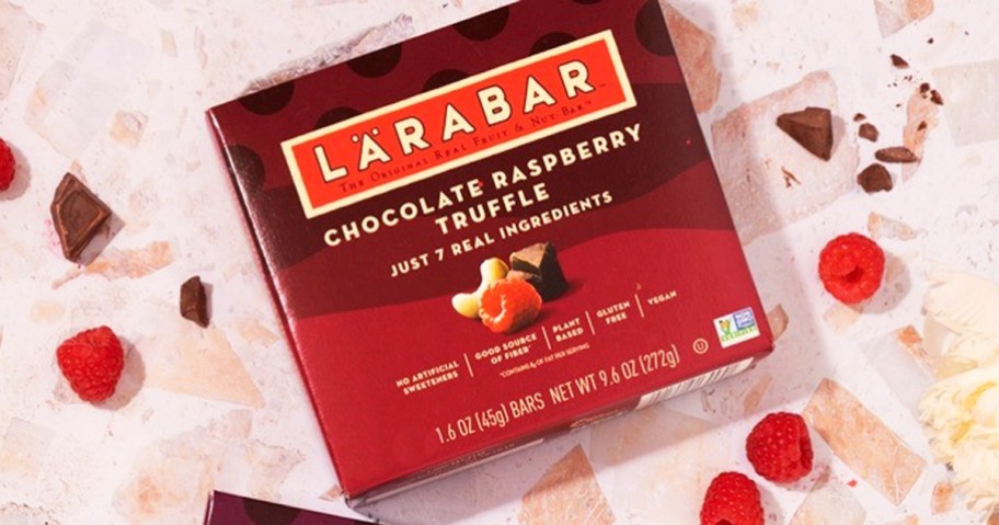 box of Larabar Chocolate Raspberry Truffle bars with chocolate pieces and raspberries around it