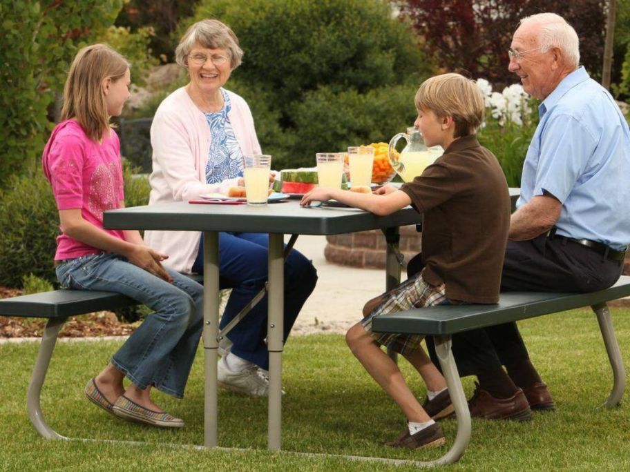 An older couple sitting with a girl and a boy on a Lifetime folding picnic table