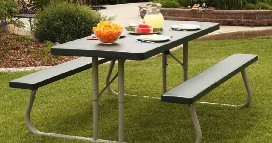A Lifetime folding picnic table with food and drinks set on it