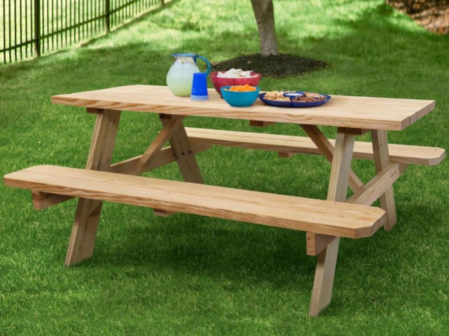A Style Selections Picnic Table from Lowes with bowls and plates of food on it