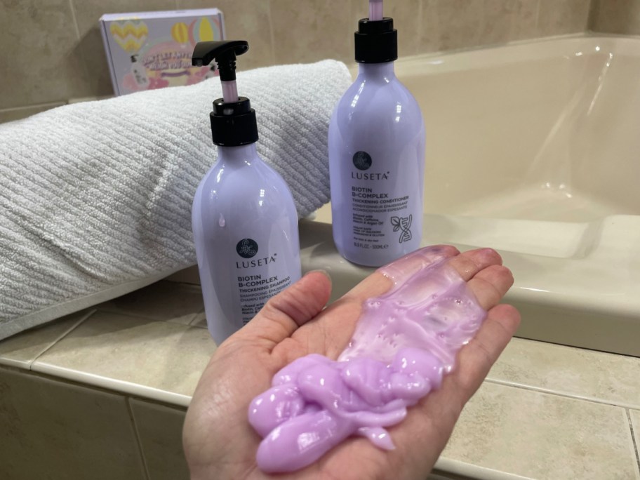 Luseta biotin shampoo and conditioner set displayed with hand showing the consistence of the products