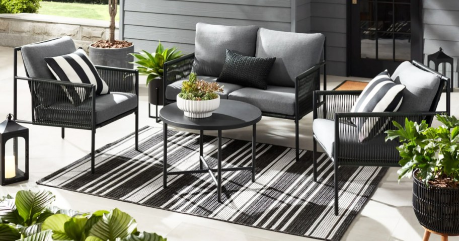 black and grey patio conversation set on a striped outdoor area rug