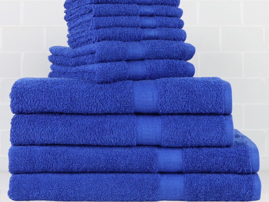 a stack of blue towels and washcloths folded on a bathroom counter