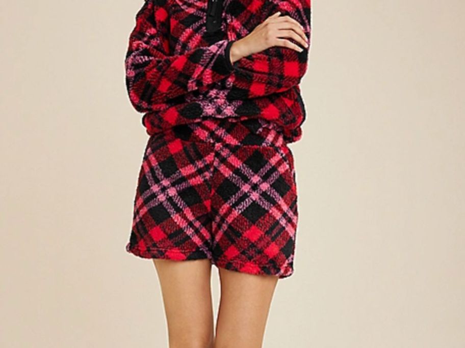 A woman wearing red plaid shorts