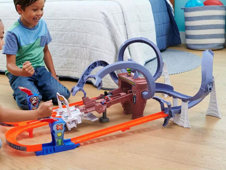 boy playing with Mattel Hot Wheels Spider-Man & Black Panther Raceverse Web-Slinging Speedway Track Set