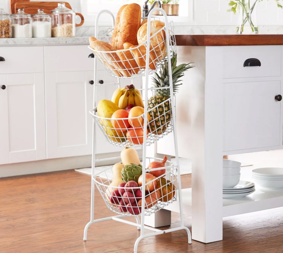 white 3-tied basket stand filled with produce in kitchen