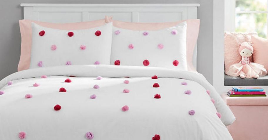 A member's mark kids white comforter with pom poms on a bed