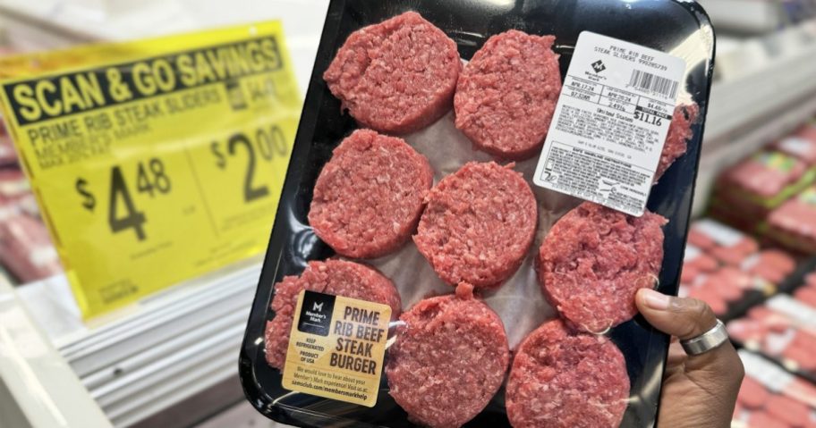 hand holding up a pack of Member's Mark Prime Rib Ground Beef Sliders with yellow scan & go sale sign in background