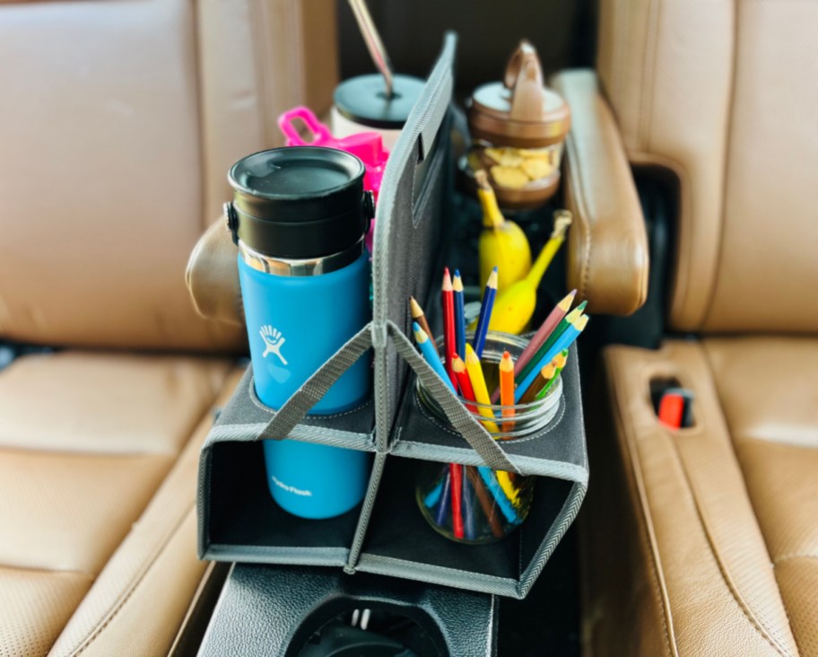 A meori car console organizer holding tumblers and colored pencils