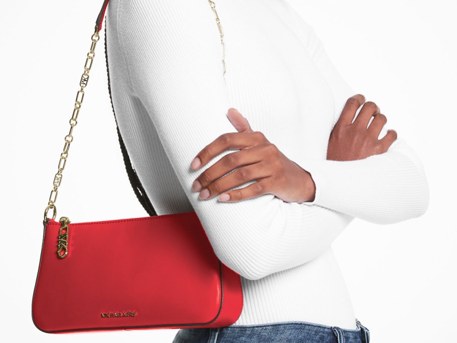 woman in white top with red shoulder bag with gold chain strap