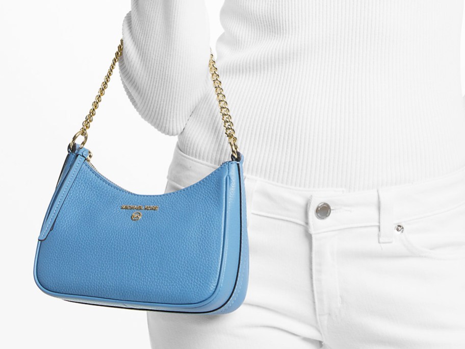 woman in all white outfit with blue handbag