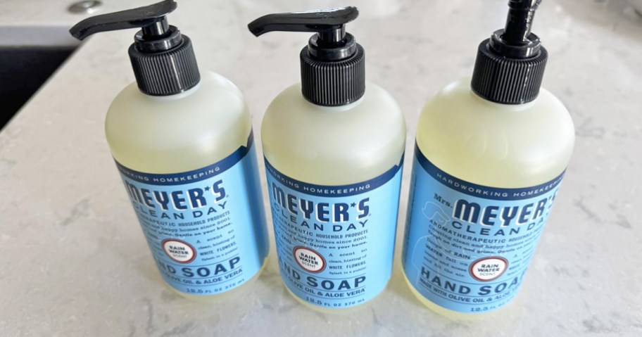 3 blue/white bottles of Mrs. Meyer's hand soap on counter