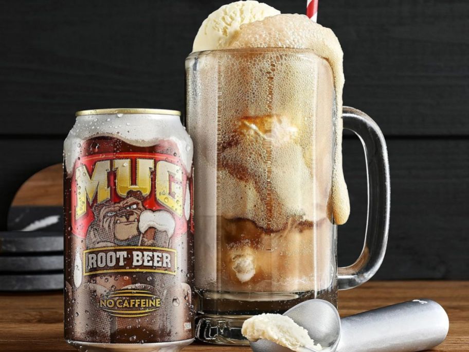 A mug of Mug root beer with a scoop of ice cream in front of it