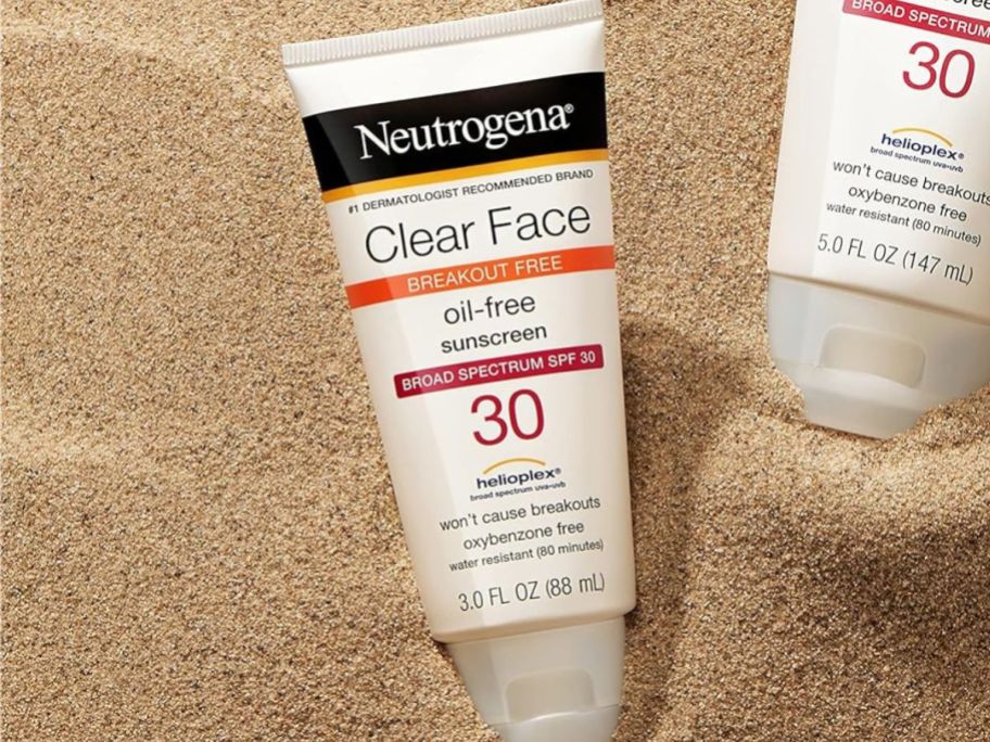 A tube of Neutrogena Clear Face Sunscreen for Acne-Prone Skin SPF 30 in the sand