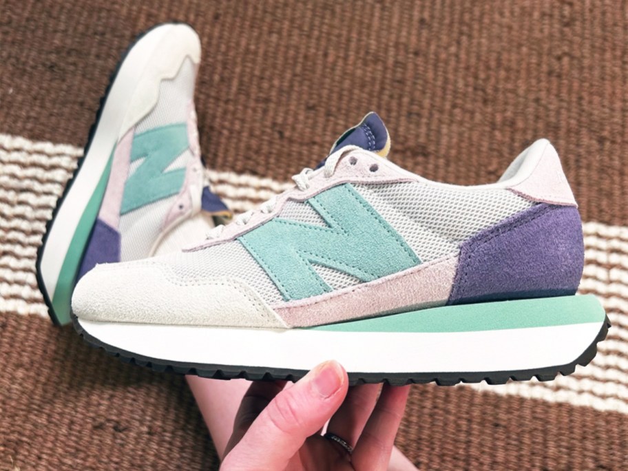 hand holding up a pastel colored new balance sneaker