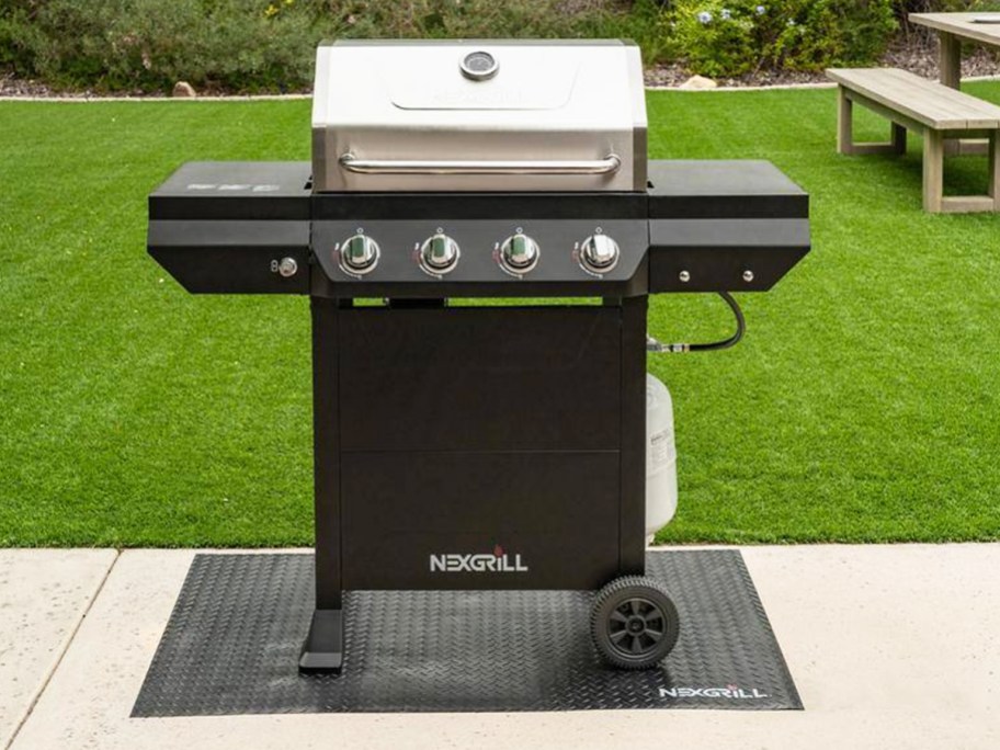 stainless steel and black propane grill in backyard