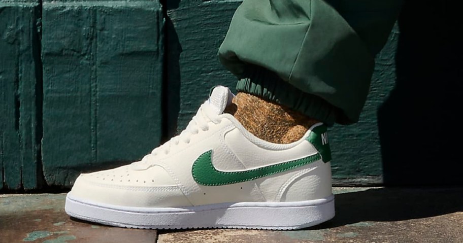 white nike sneakers with a green swoosh
