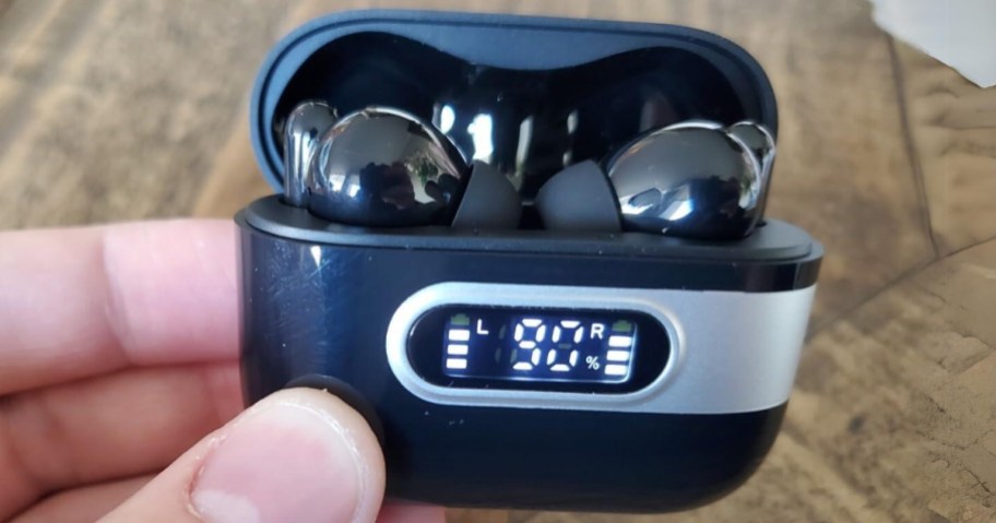 hand holding a black earbuds charging case with earbuds inside