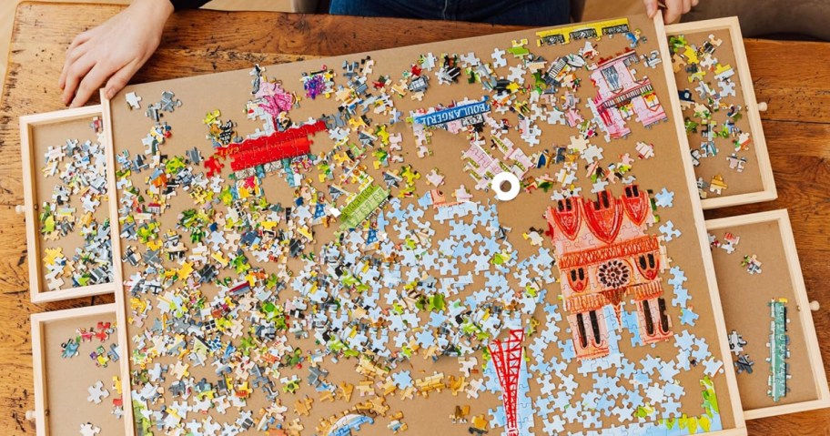 puzzle pieces scattered on a puzzle table with drawers