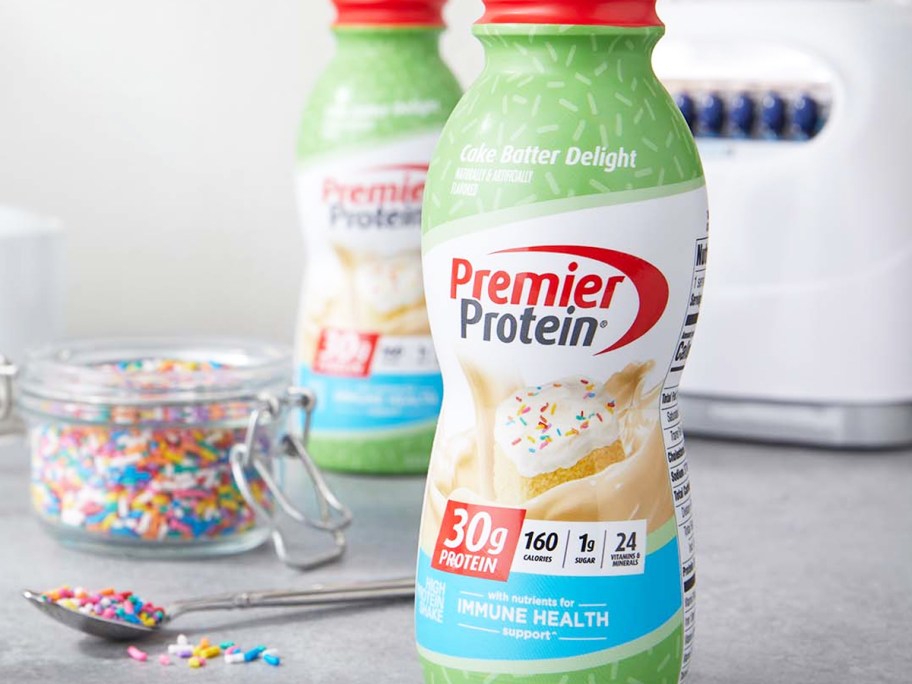 bottle of Premier Protein on counter with rainbow sprinkles in background