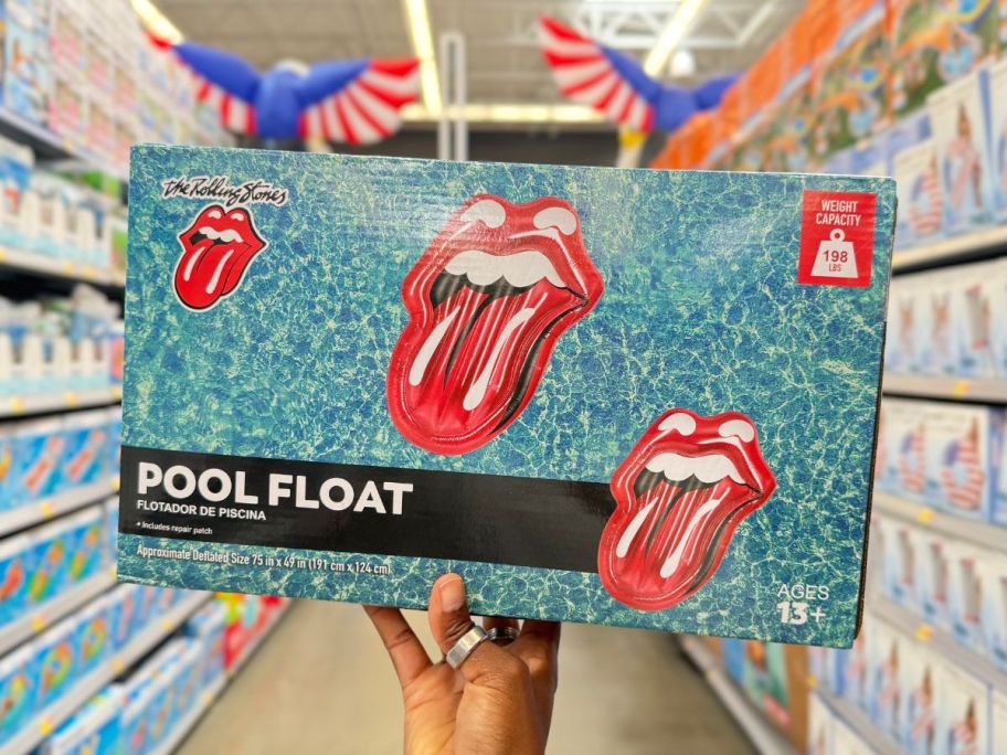 A hand holding a box with a Rolling Stones Pool Float on it 
