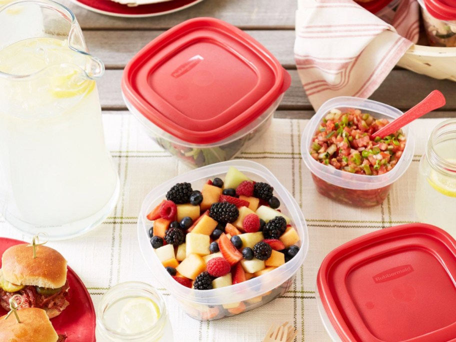 food storage container set with red lids filled with food on kitchen table