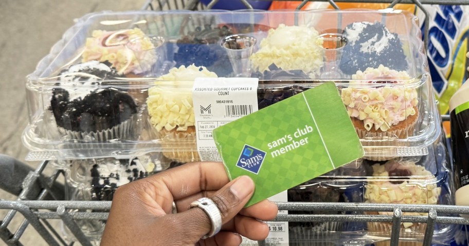 holding a sam's club membership card in front of package of cupcakes