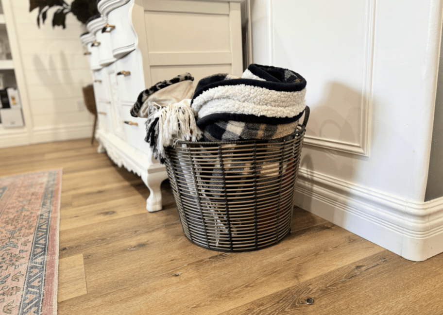 Throw blankets organized in a walmart basket with handles 