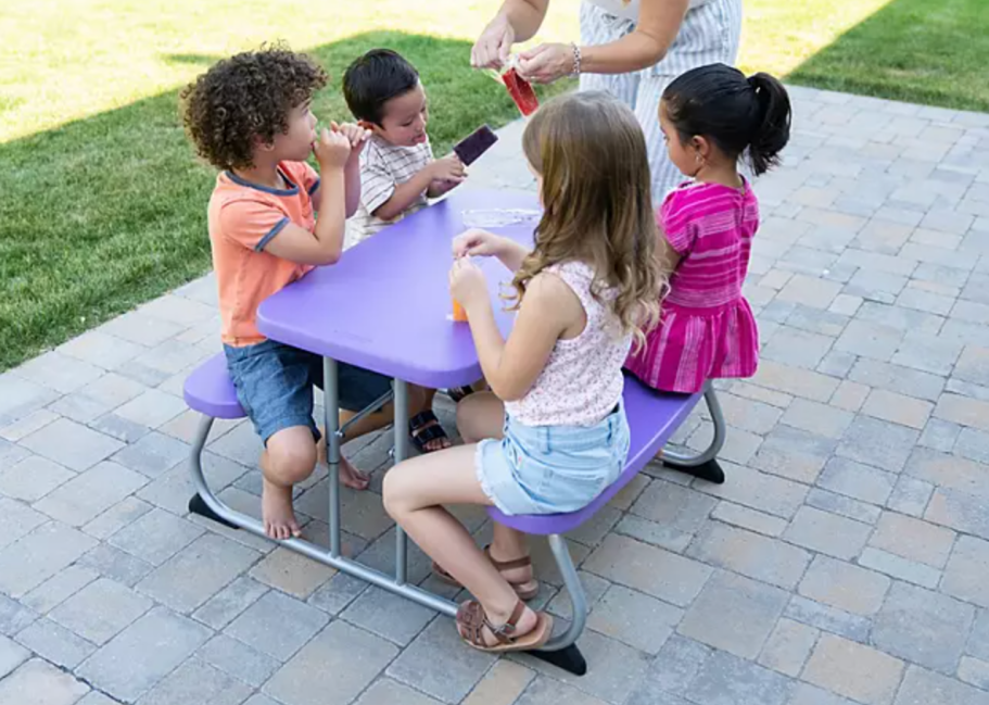 4 kids sitting at purple kids' size picnic table on patio
