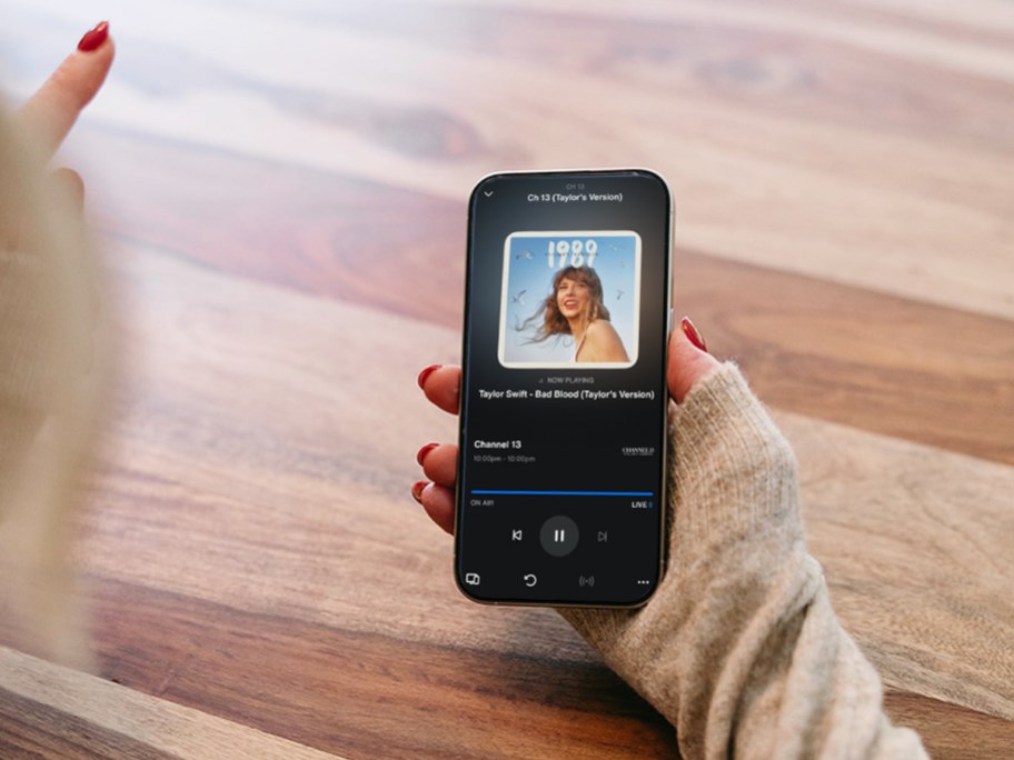woman holding phone with SiriusXM app playing Taylor Swift