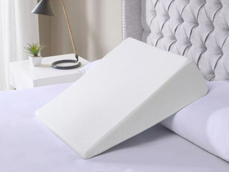 A bed with a Sleep Philosophy Memory Foam Wedge Pillow