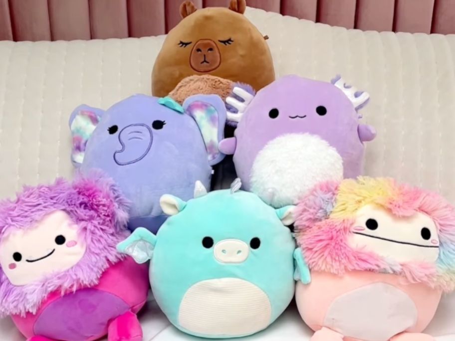 A pile of new Squishmallows from Five Below on a bed