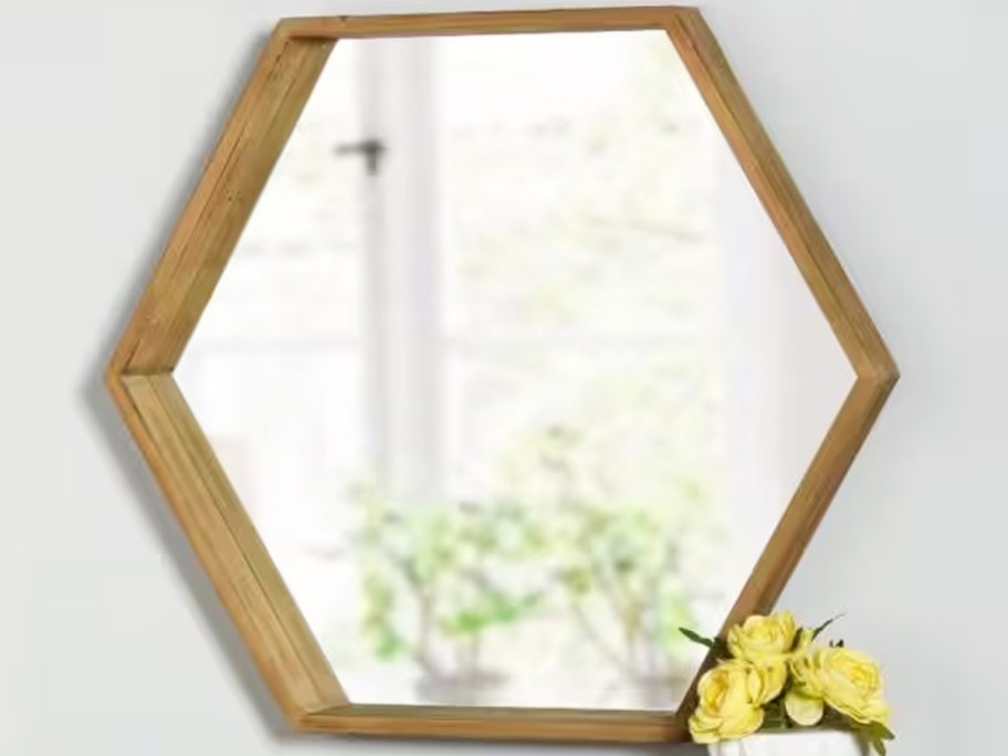 hexagon mirror with wood frame on a wall