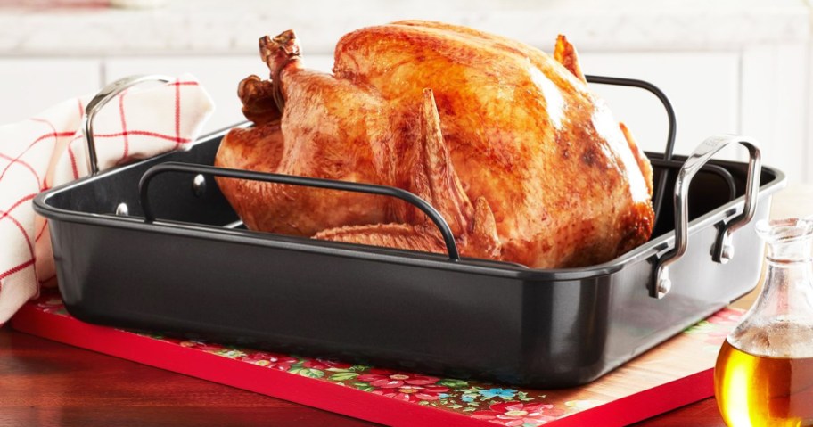 cooked turkey sitting in a black roasting pan on kitchen counter
