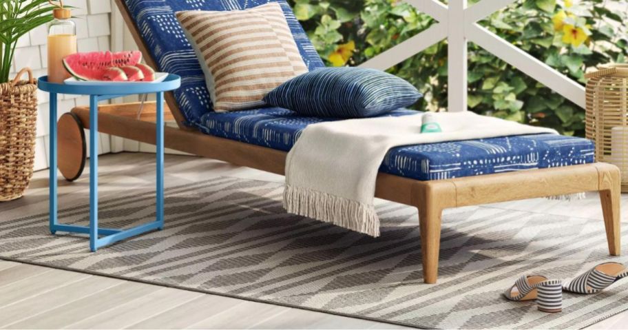 A Threshold Tapestry Geo Outdoor Rug in gray under outdoor furniture 