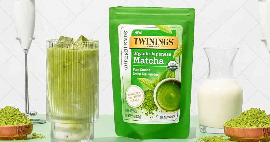 green bag of Twinings Matcha powder near green drink, hand mixer, and jar of milk