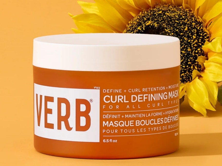container of Verb Curl Defining Mask with a sunflower behind it