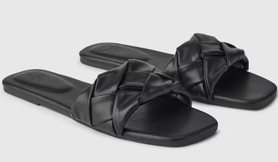 a pair of black braided vegan leather slide sandals