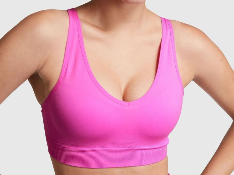 A woman bearing a pink Victoria's Secret Pink Seamless Air Medium-Impact Sports Bra
