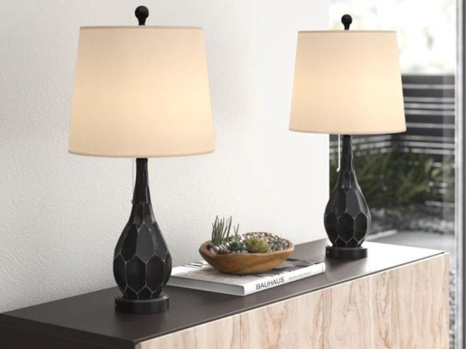 A console with two Beachcrest Home Kaelynn Resin USB Table Lamps on it